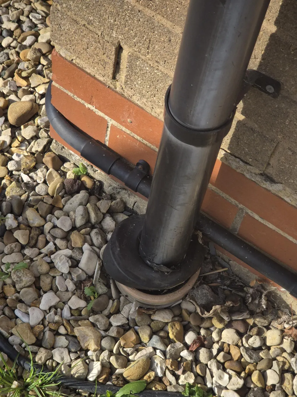 Downpipe connection sealed at ground level