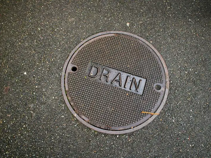 Round drain cover set in tarmac