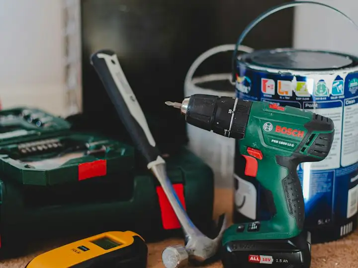 Cordless drill and hand tools on a workbench